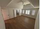 Large bedroom featuring hardwood floors, tray ceilings, and multiple windows at 504 Radford Ct, Woodstock, GA 30188