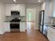 Updated kitchen features stainless steel appliances, granite countertops, and white cabinetry at 504 Radford Ct, Woodstock, GA 30188