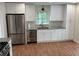 Bright kitchen with stainless steel refrigerator, modern sink, and white cabinets at 504 Radford Ct, Woodstock, GA 30188