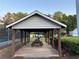 Exterior image of a white pavilion with a picnic table overlooking grassy lawn, bushes and trees at 504 Radford Ct, Woodstock, GA 30188