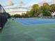Exterior view of a blue tennis court, trees, benches and a chain link fence at 504 Radford Ct, Woodstock, GA 30188