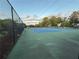Exterior view of a blue tennis court with a chain link fence and leafy trees in the background at 504 Radford Ct, Woodstock, GA 30188