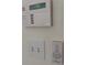 Close up of a wall with light switches, an alarm, and a fan remote at 504 Radford Ct, Woodstock, GA 30188