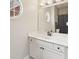Bright bathroom featuring white vanity, round window, and large mirror reflecting the shower and toilet at 75 Vinings Lake Sw Dr, Mableton, GA 30126