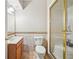 Traditional bathroom featuring a vanity sink, toilet, and glass-enclosed shower with gold trim at 75 Vinings Lake Sw Dr, Mableton, GA 30126