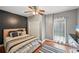 Cozy bedroom with hardwood floors, striped bedding, and dark accent wall at 75 Vinings Lake Sw Dr, Mableton, GA 30126