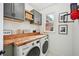 Bright laundry room features a washer and dryer, wood countertops with grey cabinets and a window at 75 Vinings Lake Sw Dr, Mableton, GA 30126