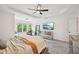 Bright main bedroom featuring a tray ceiling, ceiling fan, and a cozy sitting area with a view of the outdoors at 75 Vinings Lake Sw Dr, Mableton, GA 30126