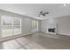 Bright living room with a fireplace, ceiling fan, hardwood floors, and large windows providing ample natural light at 285 Camden Park Dr, Lawrenceville, GA 30046