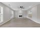 Spacious living room featuring a fireplace, ceiling fan, hardwood floors, and bright windows providing natural light at 285 Camden Park Dr, Lawrenceville, GA 30046