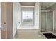 Bright bathroom featuring a soaking tub under a window and a separate glass-enclosed shower at 3715 Frankie Wade Ln, Loganville, GA 30052