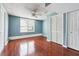 A spacious bedroom featuring hardwood floors, a ceiling fan, and a large window at 3715 Frankie Wade Ln, Loganville, GA 30052