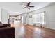 Open concept living room and kitchen area with wood flooring, ceiling fan, and large windows at 3715 Frankie Wade Ln, Loganville, GA 30052