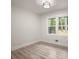 Bedroom featuring light-colored wood floors, white walls, modern ceiling light, and windows looking out to greenery at 140 Larose Se Cir, Marietta, GA 30060