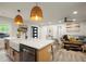 Open-concept kitchen flows into the living area, featuring a farmhouse sink and breakfast bar with pendant lights at 140 Larose Se Cir, Marietta, GA 30060