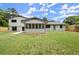 Spacious backyard showing lush lawn, enclosed porch, brick exterior, and privacy fence at 1863 Trumbull Dr, Atlanta, GA 30338