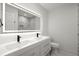 Stylish bathroom with dual sinks, marble accents, lighted mirror, and modern toilet at 1863 Trumbull Dr, Atlanta, GA 30338