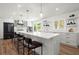 Modern white kitchen with a large island, stainless steel appliances, and hardwood floors at 1863 Trumbull Dr, Atlanta, GA 30338