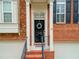 Close up of an elegant doorway framed by columns, red brick, and black shutters and door with wreath at 4888 Colchester Se Ct # 3, Atlanta, GA 30080
