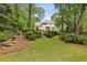 Beautiful backyard featuring a well-manicured lawn, lush landscaping, and an elegant multi-story home at 520 Flying Scot Way, Alpharetta, GA 30005