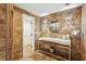 Stylish bathroom featuring brick walls, a modern vanity with a chrome stand, and a round mirror at 520 Flying Scot Way, Alpharetta, GA 30005