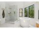 Bright bathroom featuring a glass shower, soaking tub, and large windows with a private view at 520 Flying Scot Way, Alpharetta, GA 30005