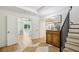 Bright entryway leading to a bedroom, featuring a wooden table and stairs at 520 Flying Scot Way, Alpharetta, GA 30005