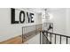 Hallway with modern light fixture, stylish artwork, and staircase with black metal railing at 520 Flying Scot Way, Alpharetta, GA 30005