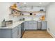 Charming kitchenette featuring blue cabinets, marble countertops, and open wood shelving at 520 Flying Scot Way, Alpharetta, GA 30005