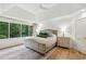 Bright main bedroom with tray ceiling, hardwood floors, and view of the lush, green yard at 520 Flying Scot Way, Alpharetta, GA 30005