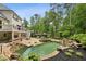 Backyard with a luxurious pool, waterfall features, hot tub, patio area, and lush landscaping at 520 Flying Scot Way, Alpharetta, GA 30005