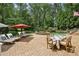 Backyard pool with stone patio, lounge chairs, outdoor dining, and a waterfall feature surrounded by lush landscaping at 520 Flying Scot Way, Alpharetta, GA 30005