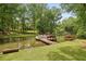 Scenic waterfront view with a boat docked, mature trees, and a beautiful lawn at 520 Flying Scot Way, Alpharetta, GA 30005