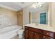 Bright bathroom featuring a large mirror, granite vanity, and tile tub-shower combo at 2313 Millhaven St, Smyrna, GA 30080
