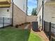 Narrow landscaped backyard between homes, with AC unit and walkway visible at 173 Basil St, Cumming, GA 30040