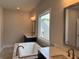 Bathroom featuring soaking tub and double sinks with modern lighting and a large window at 173 Basil St, Cumming, GA 30040
