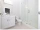 Modern bathroom with glass shower, white vanity, and neutral tile floors at 173 Basil St, Cumming, GA 30040