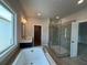 Bathroom with glass shower, soaking tub, double sinks, and a large window at 173 Basil St, Cumming, GA 30040