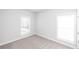 Bedroom with carpeted floor, two windows with blinds, and neutral paint at 173 Basil St, Cumming, GA 30040