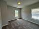 Carpeted bedroom with light walls and trim and two windows with neighborhood views at 173 Basil St, Cumming, GA 30040