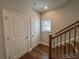 Hardwood hallway with coat closet, adjacent to hardwood staircase with iron railing at 173 Basil St, Cumming, GA 30040