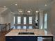 A open-concept kitchen boasts an island with seating and stainless steel appliances at 173 Basil St, Cumming, GA 30040