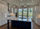Modern kitchen with marble island, white cabinets, and stainless steel appliances at 173 Basil St, Cumming, GA 30040