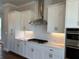 Bright kitchen boasts white cabinets, quartz countertop and stainless steel appliances at 173 Basil St, Cumming, GA 30040
