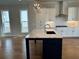 A kitchen boasts white cabinets, a marble countertop island and stainless steel appliances at 173 Basil St, Cumming, GA 30040