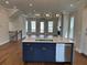 Gleaming kitchen with stainless appliances, marble island, and views of the living area at 173 Basil St, Cumming, GA 30040