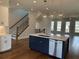 Charming kitchen island view showcases stairs and an airy open concept design at 173 Basil St, Cumming, GA 30040