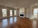 Bright living room showcasing hardwood floors, a ceiling fan, a fireplace, and natural light through large windows at 173 Basil St, Cumming, GA 30040