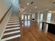 Spacious living room with hardwood floors, staircase, fireplace, and lots of natural light at 173 Basil St, Cumming, GA 30040