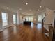 Open-concept living area leading to a modern kitchen island and staircase, filled with natural light at 173 Basil St, Cumming, GA 30040
